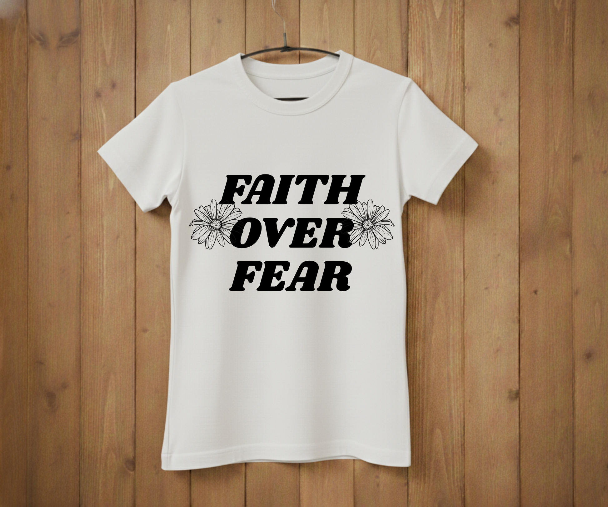 White t-shirt with 'Faith Over Fear' text on a wooden background