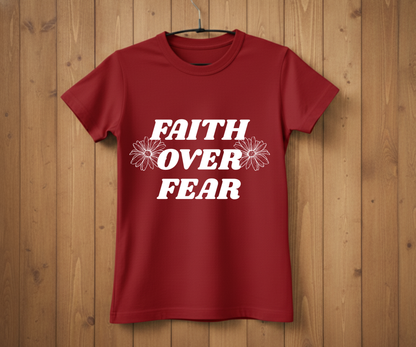 Red t-shirt with 'Faith Over Fear' text on a wooden background