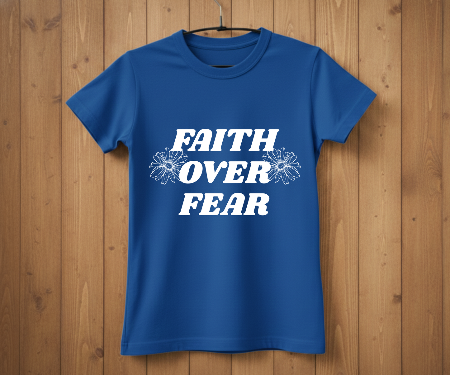 Blue t-shirt with 'Faith Over Fear' text on a wooden background