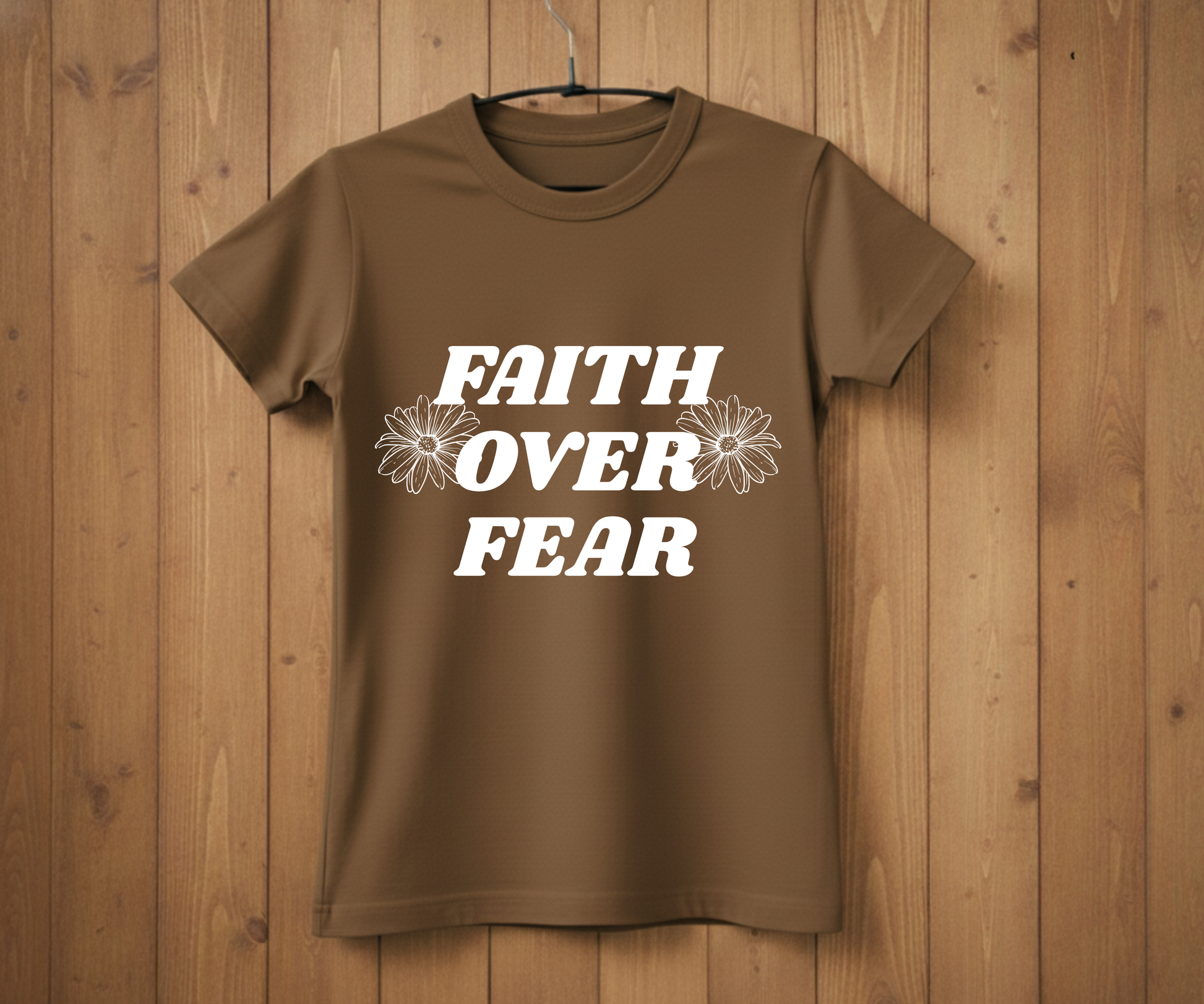 Brown t-shirt with 'Faith Over Fear' text on a wooden background