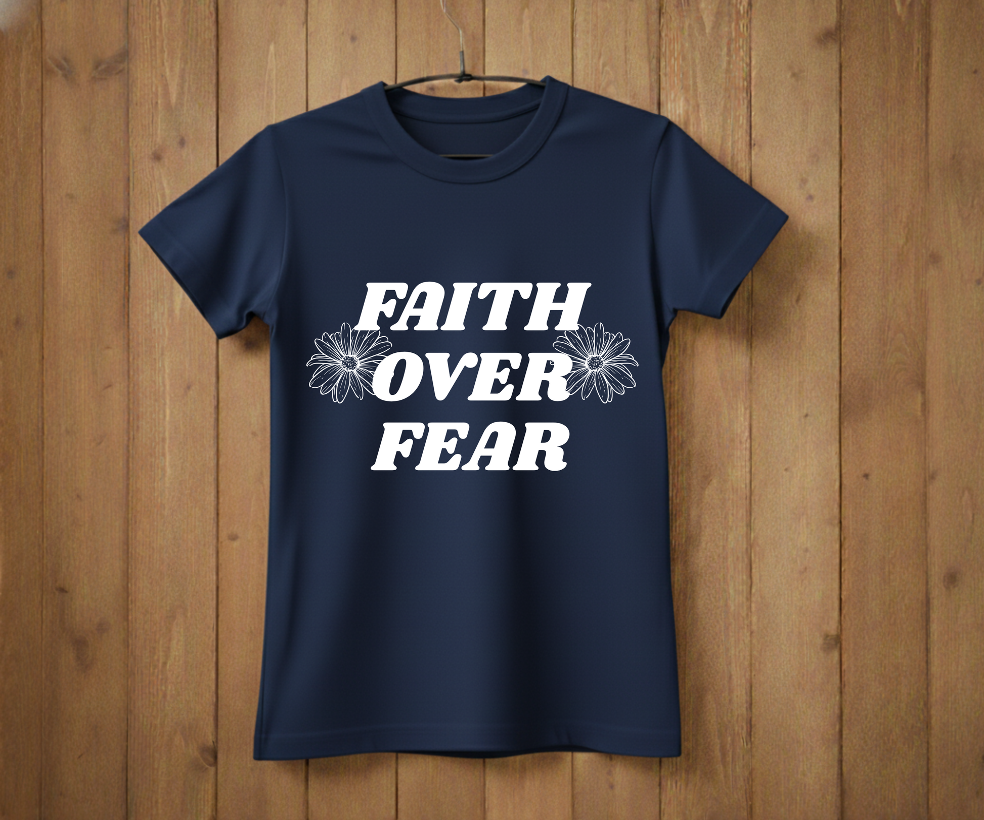 Navy blue t-shirt with 'Faith Over Fear' text on a wooden background