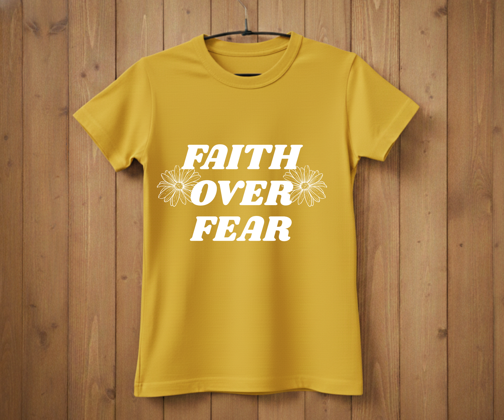 Yellow t-shirt with 'Faith Over Fear' text on a wooden background