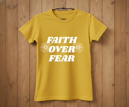 Yellow t-shirt with 'Faith Over Fear' text on a wooden background