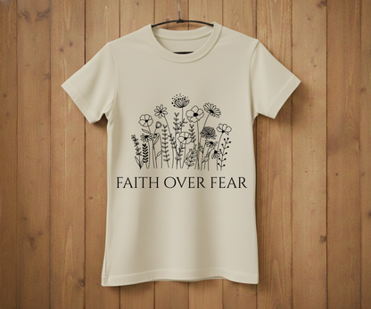 Beige t-shirt with floral design and 'Faith Over Fear' text on a wooden background
