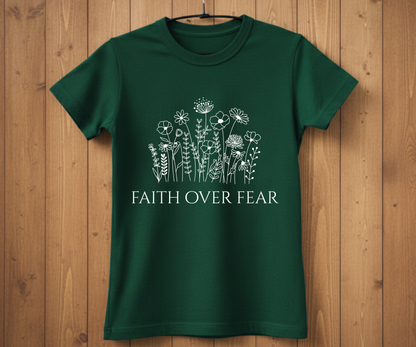 Green t-shirt with floral design and 'Faith Over Fear' text on a wooden background