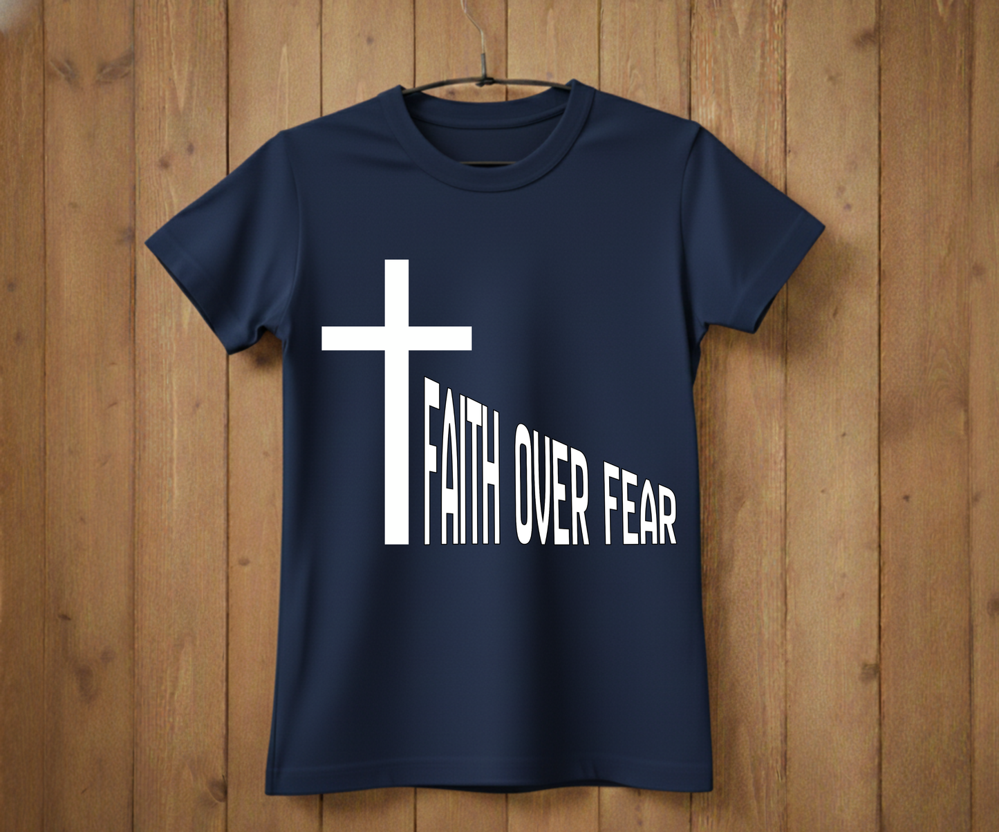 Navy blue t-shirt with a white cross and 'Faith Over Fear' text on a wooden background