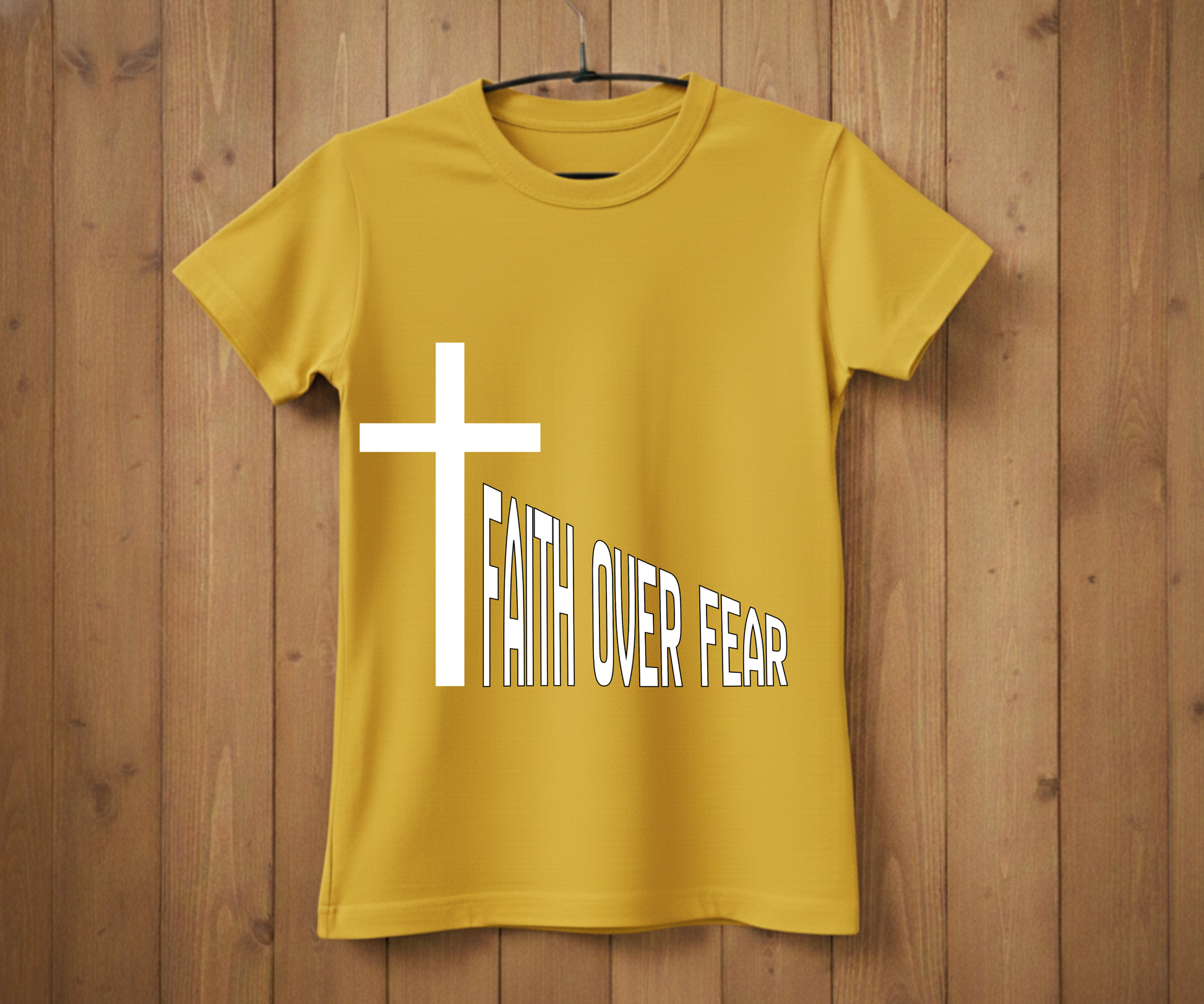 Yellow t-shirt with a white cross and 'Faith Over Fear' text on a wooden background