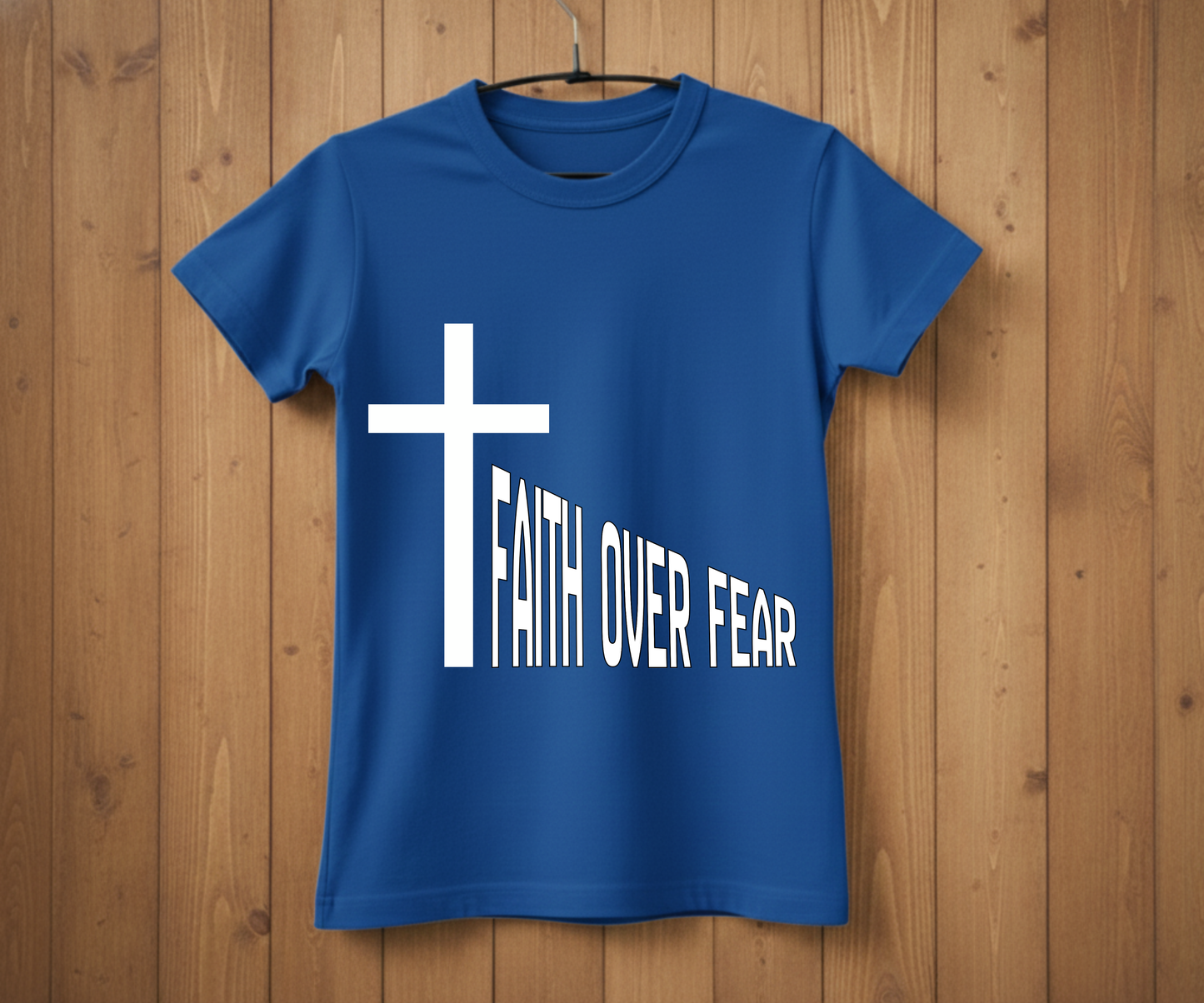Blue t-shirt with a white cross and 'Faith Over Fear' text on a wooden background