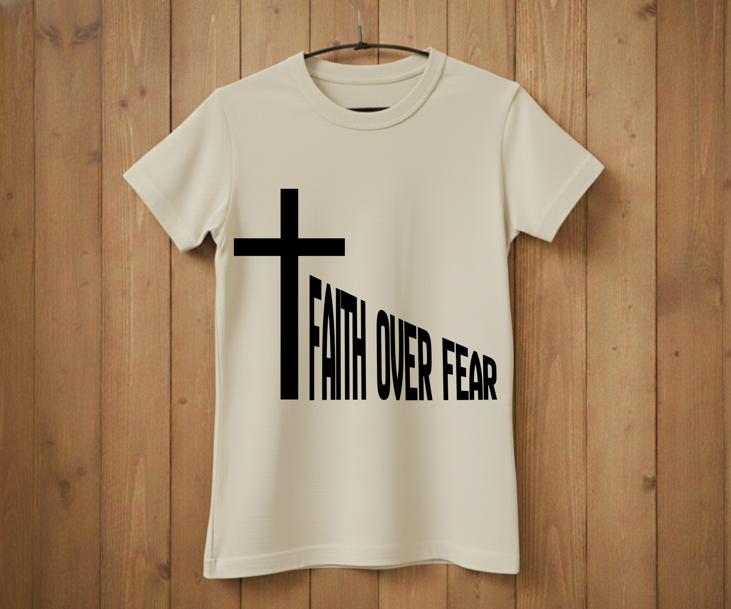 White t-shirt with a black cross and 'Faith Over Fear' text on a wooden background