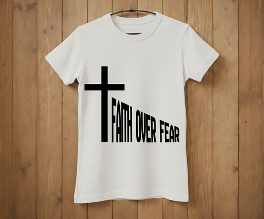 White t-shirt with a black cross and 'Faith Over Fear' text on a wooden background