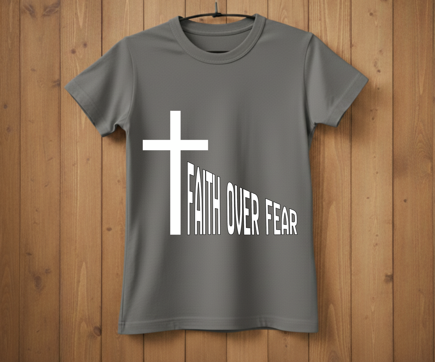 Gray t-shirt with a white cross and 'FAITH OVER FEAR' text on a wooden background