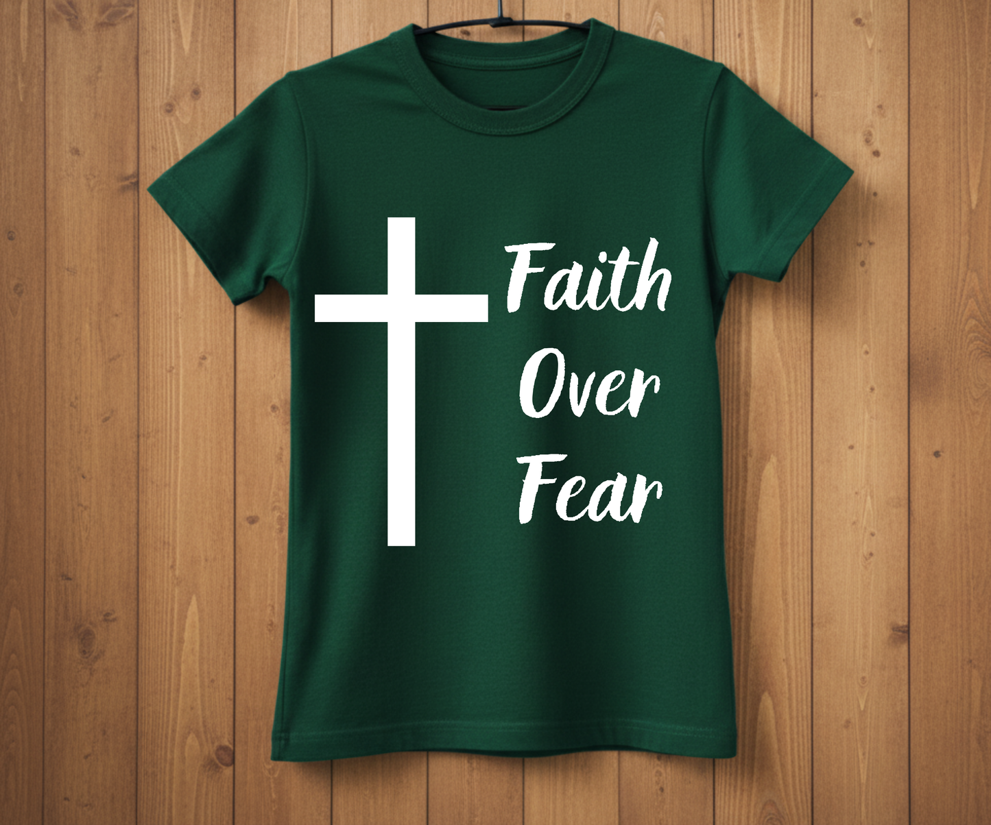 Green t-shirt with a white cross and 'Faith Over Fear' text on a wooden background