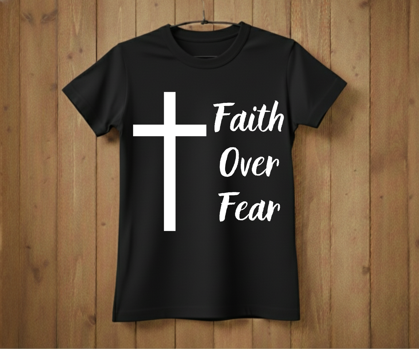 Black t-shirt with a white cross and 'Faith Over Fear' text on a wooden background