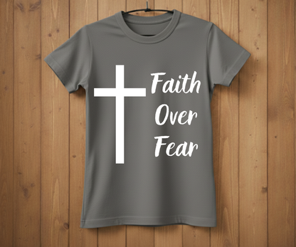 Gray t-shirt with a white cross and 'Faith Over Fear' text on a wooden background