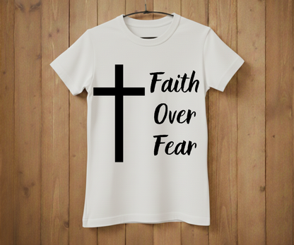 White t-shirt with a black cross and 'Faith Over Fear' text on a wooden background