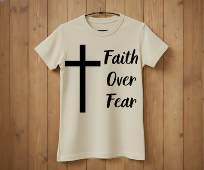 White t-shirt with a black cross and 'Faith Over Fear' text on a wooden background