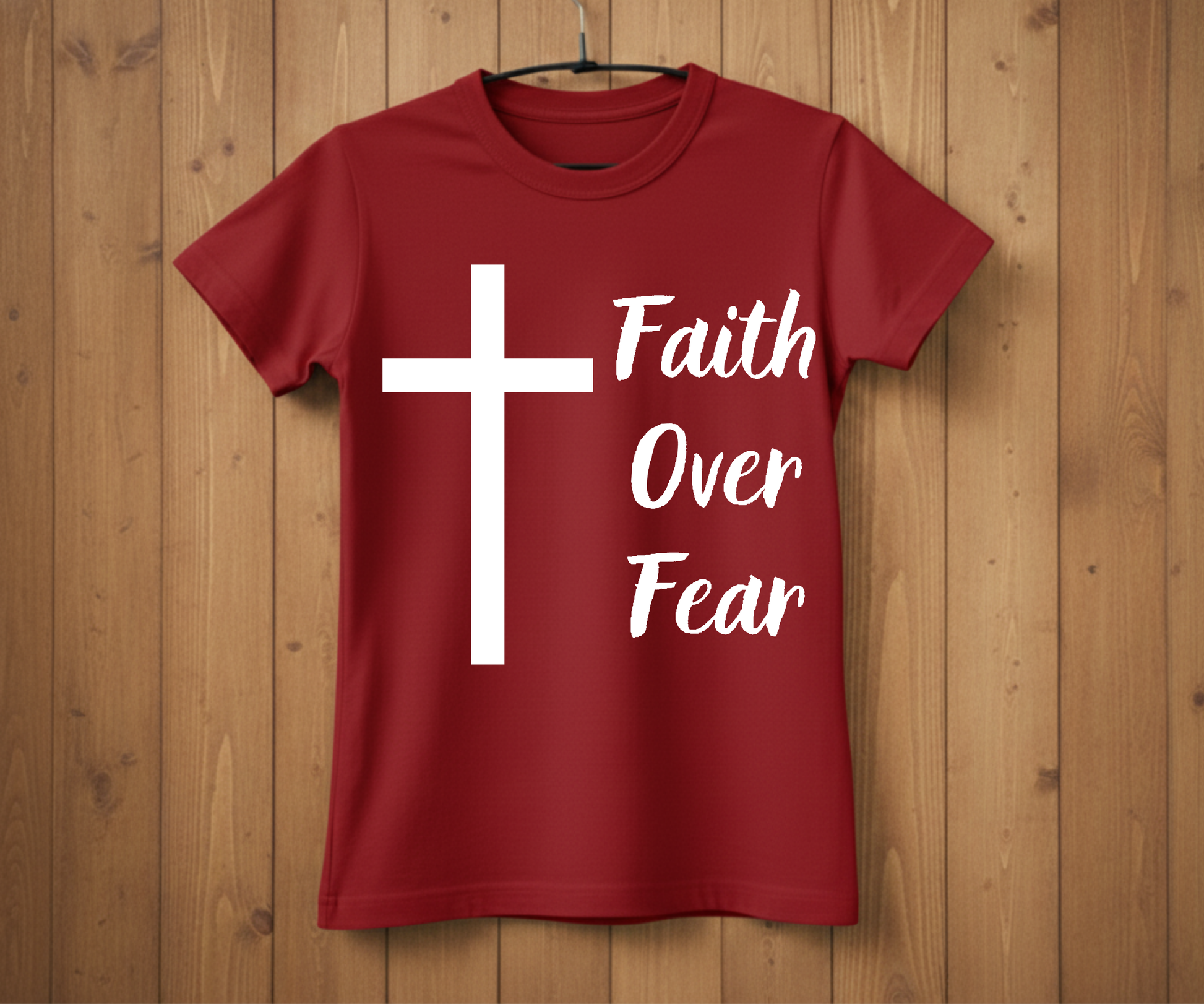 Red t-shirt with a white cross and 'Faith Over Fear' text on a wooden background