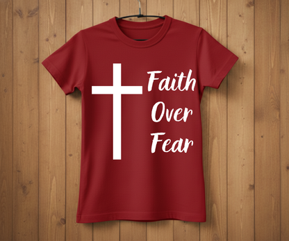 Red t-shirt with a white cross and 'Faith Over Fear' text on a wooden background