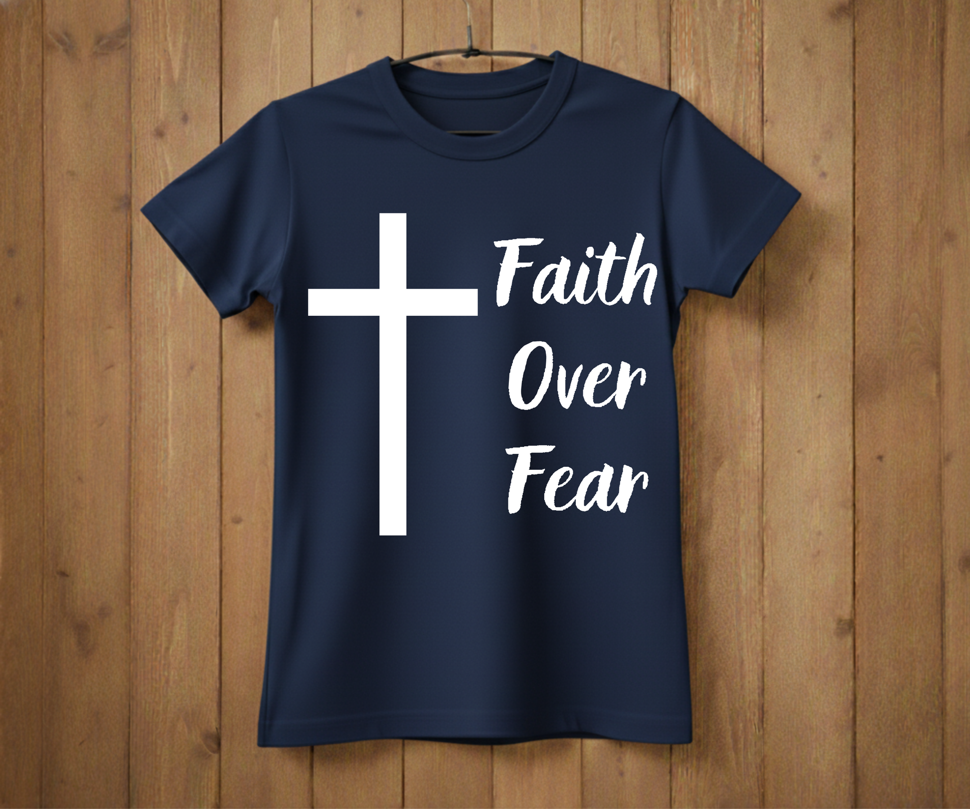 Navy blue t-shirt with a white cross and 'Faith Over Fear' text on a wooden background